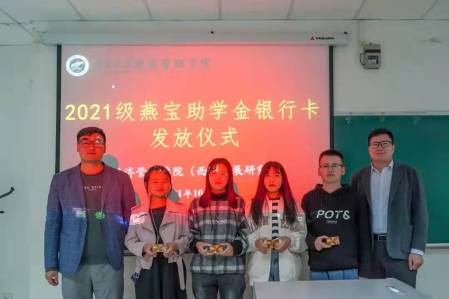 经济管理学院辅导员艾萨•阿尤普、禹文杰向获奖新生发放燕宝银行卡